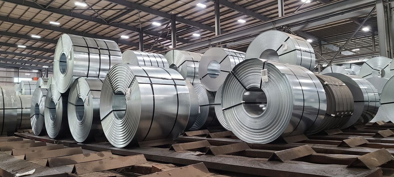 Stacks of galvanized steel coils preparing for shipment on the facility floor.