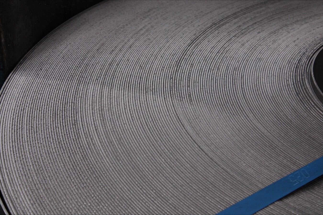 A closeup of a steel coil sideway that is banded.
