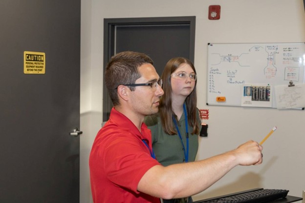 Two material scientists from Worthington Steel working on testing various materials for customers.