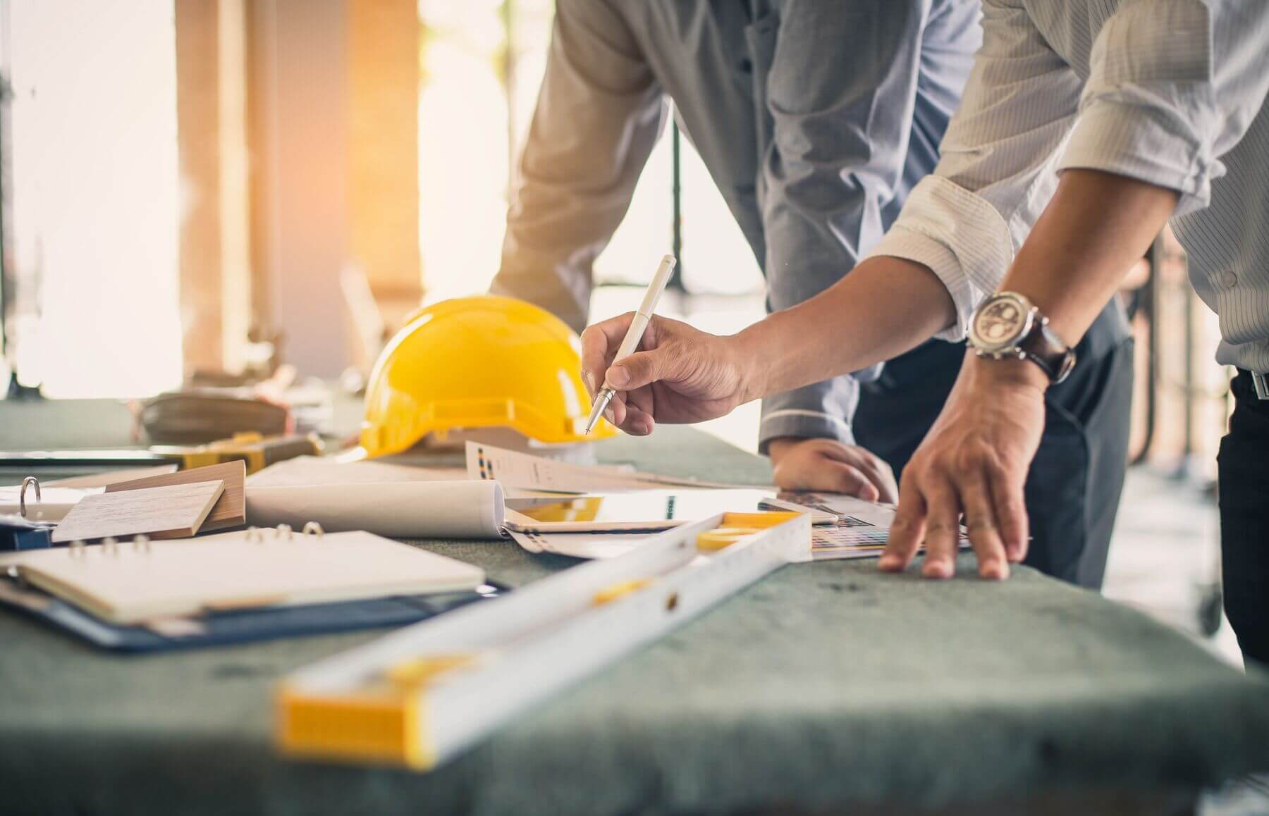 Stock photo of employees looking over construction plans.