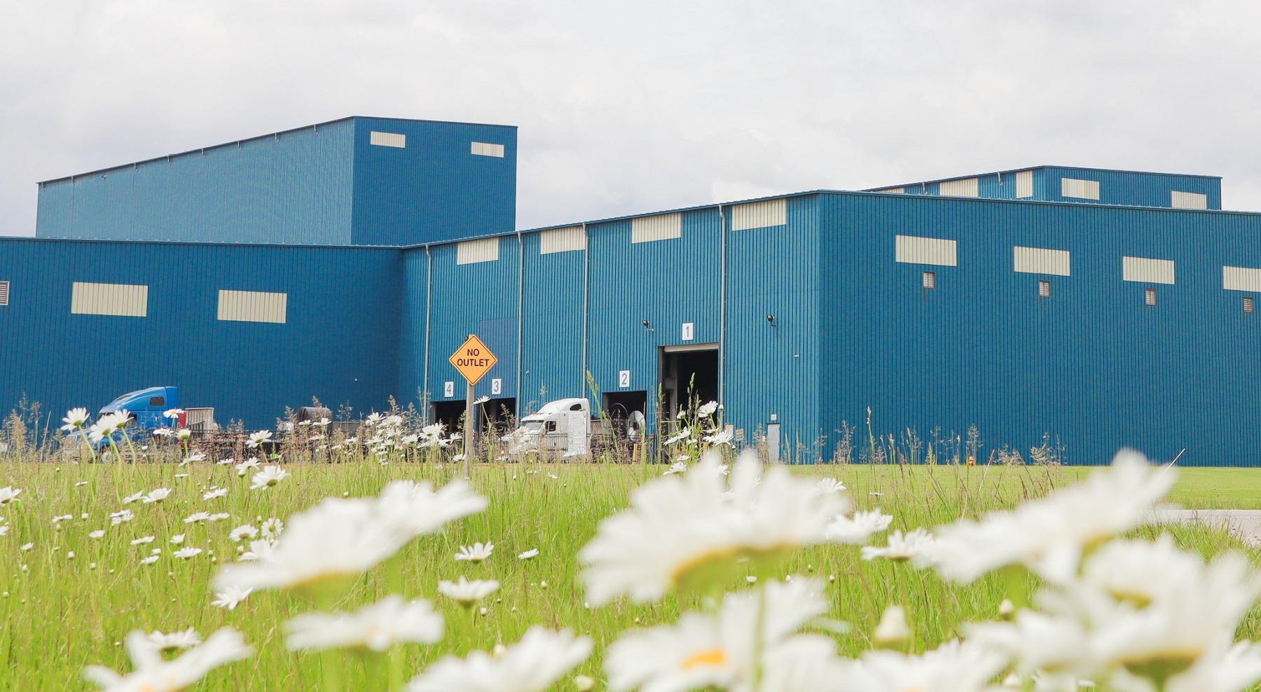 Exterior of a Worthington Steel processing facility in Delta, Ohio with flowers in the foreground.