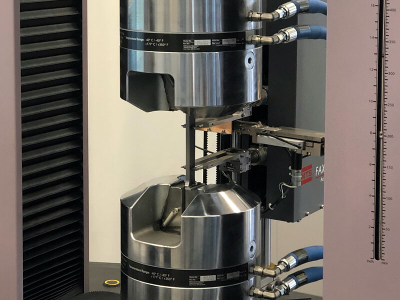 A closeup of our universal testing machine (UTM) that stretches a piece of steel to test specific properties.