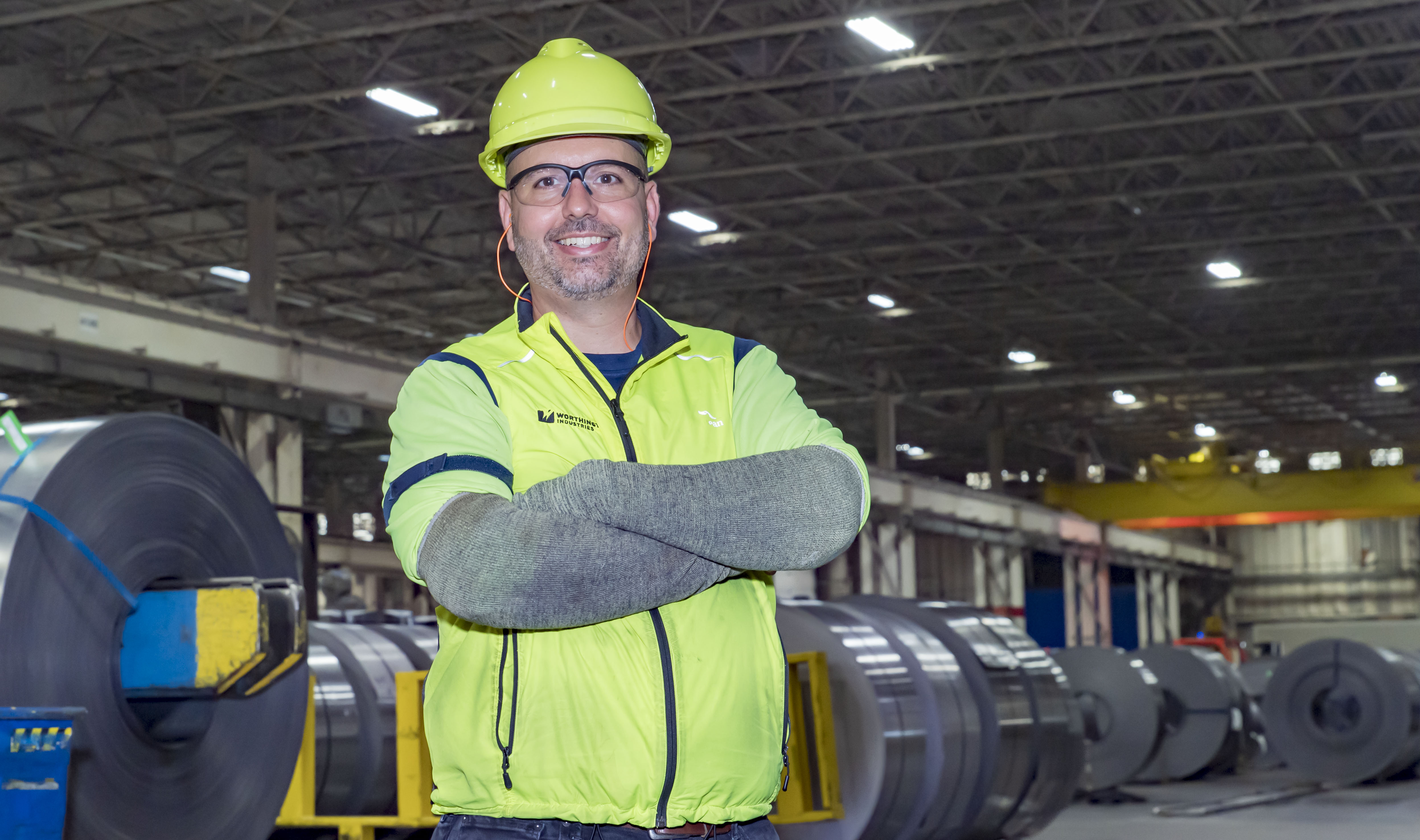 Worthington Steel employee in a steel processing facility wearing personal protective equipment (PPE).