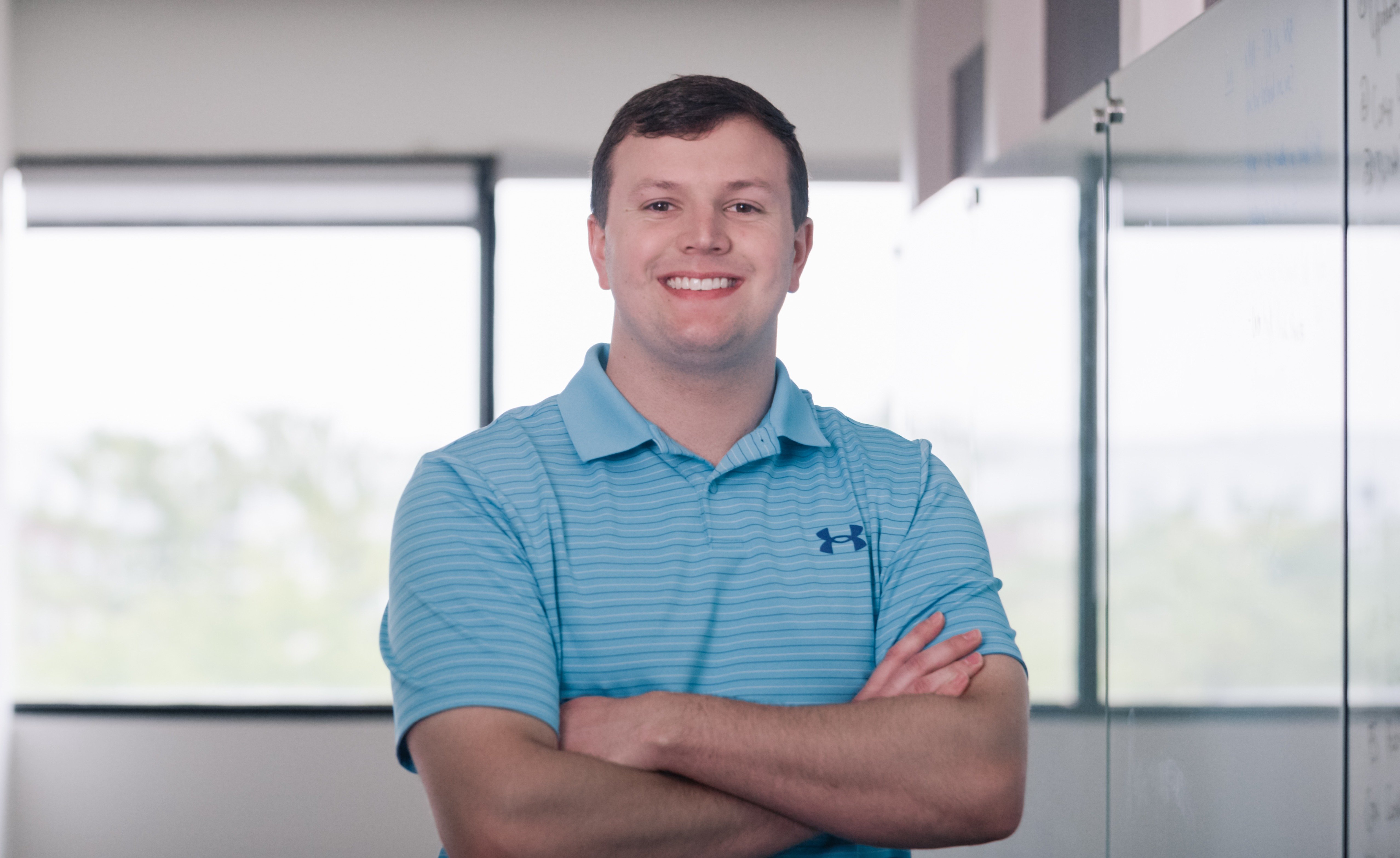 Employee standing tall with arms crossed, smiling